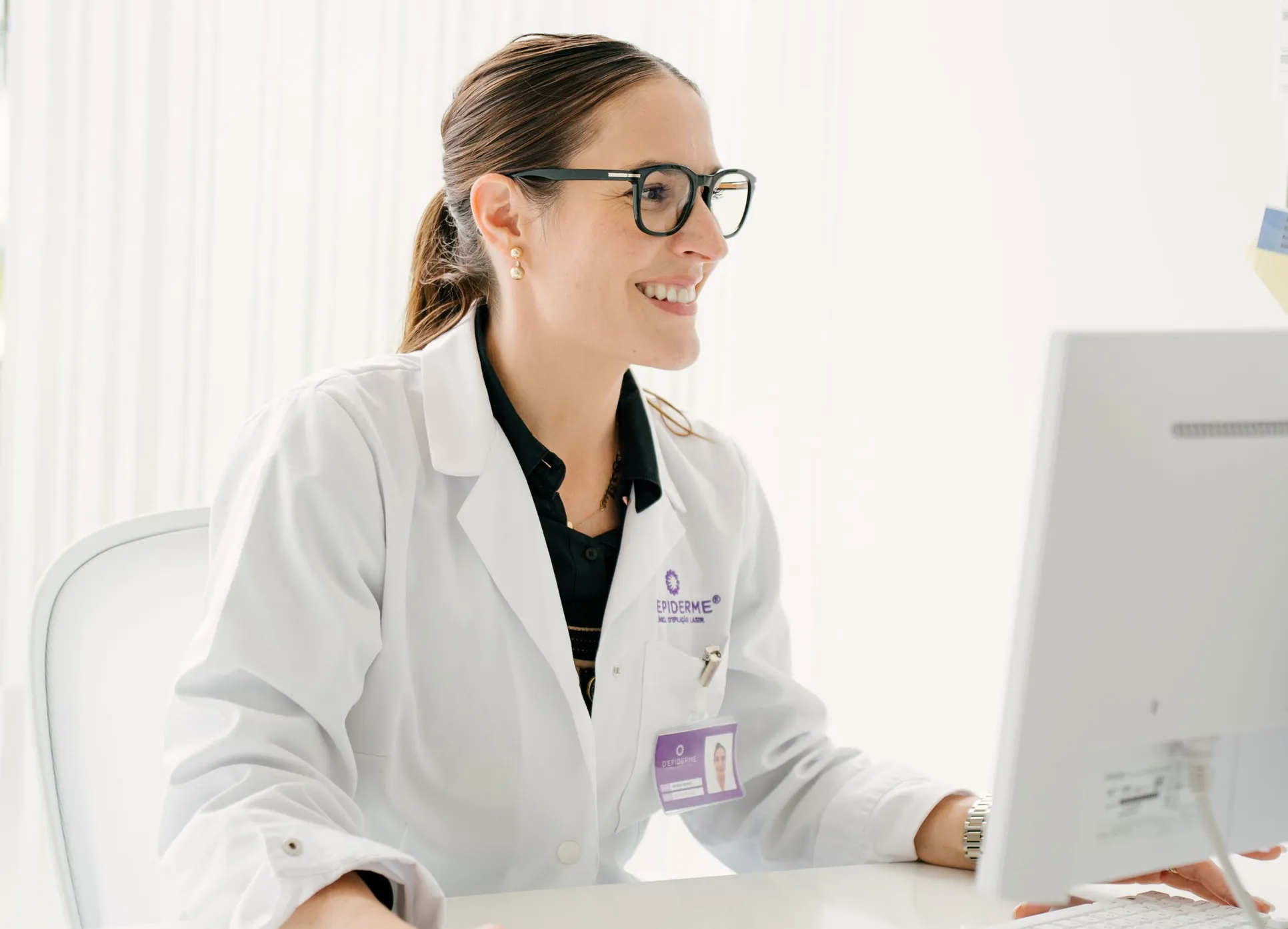 Profissional de saúde da Depiderme ao computador numa clínica